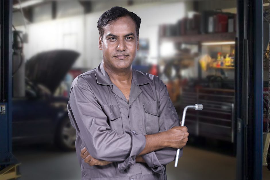 Friendly and professional auto mechanic smiling at the shop
